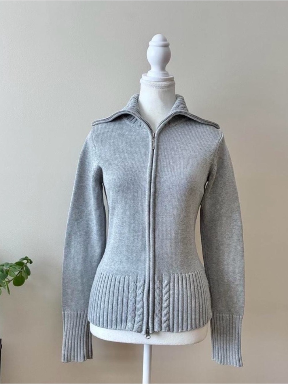 Grey zip up sweater with pleated hem and cable knit details